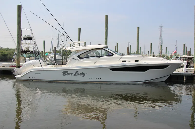 Slide: The Image of 2024 Pursuit OS 405 Offshore boat docked at marina, side view. - 2