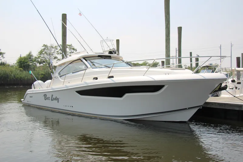 Slide: The Image of 2024 Pursuit OS 405 Offshore boat docked in a marina, showcasing sleek design and modern features. - 4