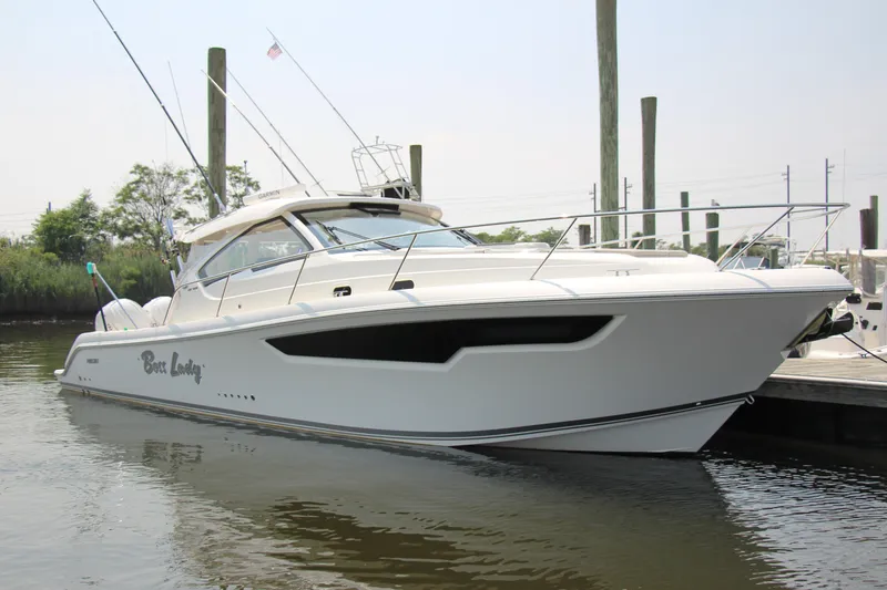 The Image of 2024 Pursuit OS 405 Offshore boat docked in a marina, showcasing sleek design and modern features. - 0