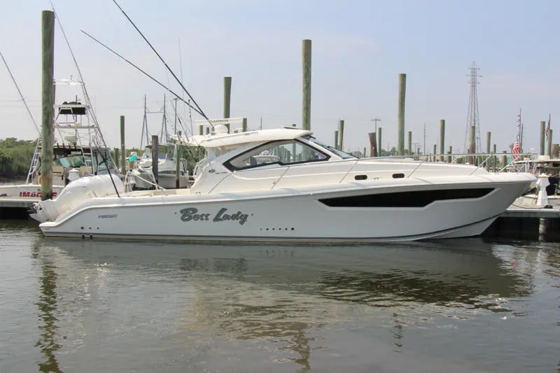 Slide: The Image of 2024 Pursuit OS 405 Offshore boat docked at marina, side view. - 1