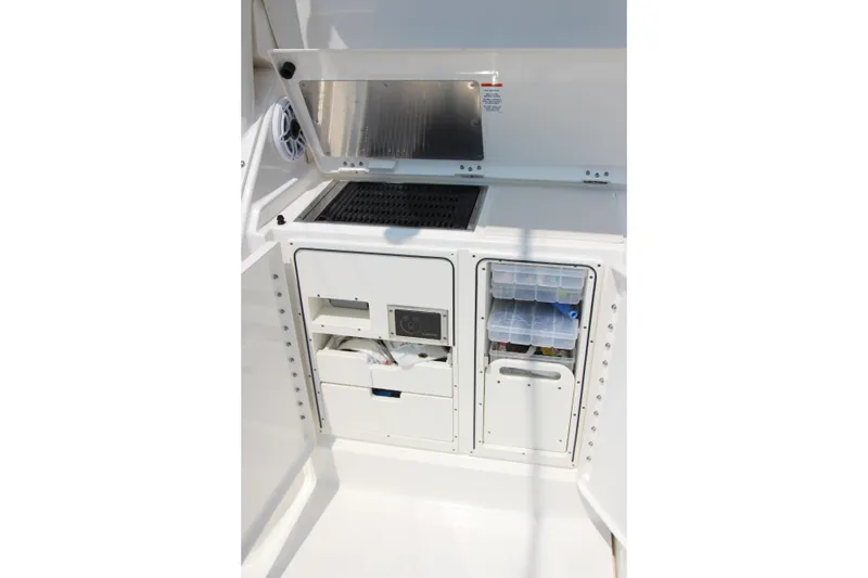 Slide: The Image of 2024 Pursuit OS 405 Offshore boat storage compartments with organized tackle boxes and equipment. - 10