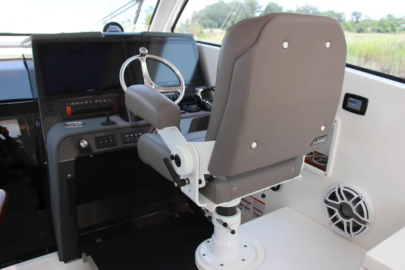 Slide: The Image of Helm station of 2024 Pursuit OS 405 Offshore boat with captain's chair and control panel. - 16