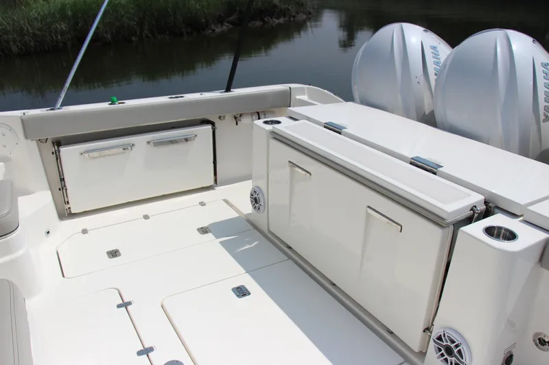 Slide: The Image of 2024 Pursuit OS 405 Offshore boat deck with storage compartments and Yamaha engines. - 13