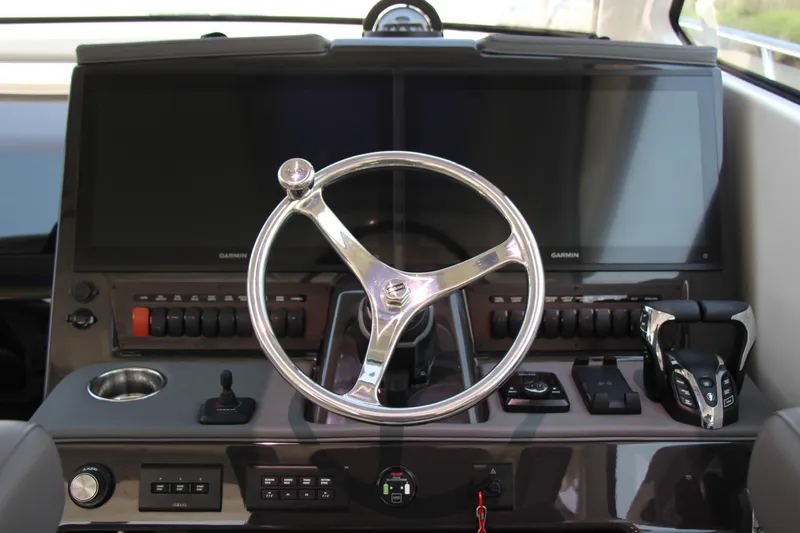 Slide: The Image of Helm of 2024 Pursuit OS 405 Offshore boat with dual Garmin displays and controls. - 17