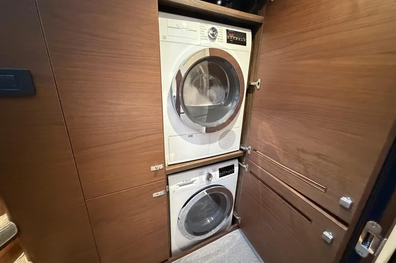 Slide: The Image of Stacked washer and dryer in a 2020 Princess S78 yacht's wooden cabinet. - 59