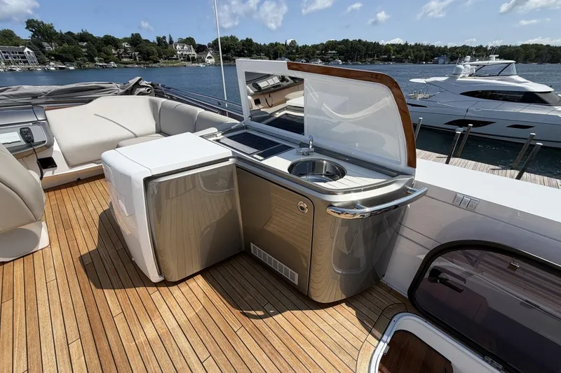 Slide: The Image of Luxurious 2020 Princess S78 yacht deck with kitchenette and seating, docked by serene waterfront. - 76