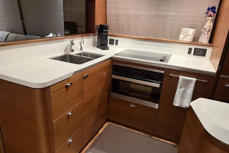 Slide: The Image of Modern kitchen in a 2020 Princess S78 yacht with sleek wood cabinetry and stainless steel appliances. - 34
