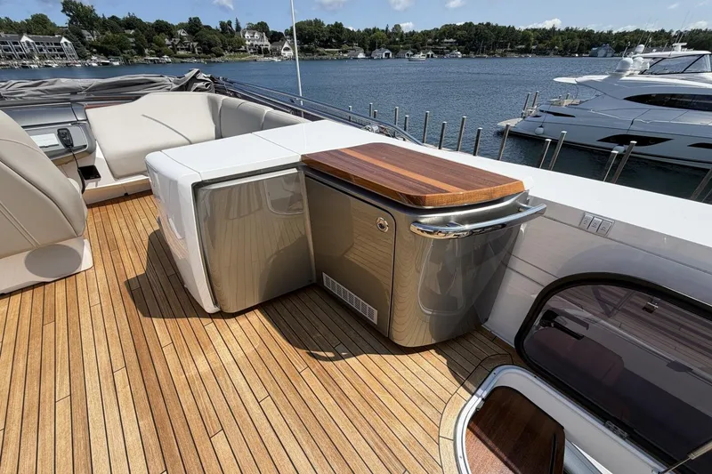 Slide: The Image of Luxurious 2020 Princess S78 yacht deck with elegant seating and wooden accents, docked by a serene waterfront. - 75