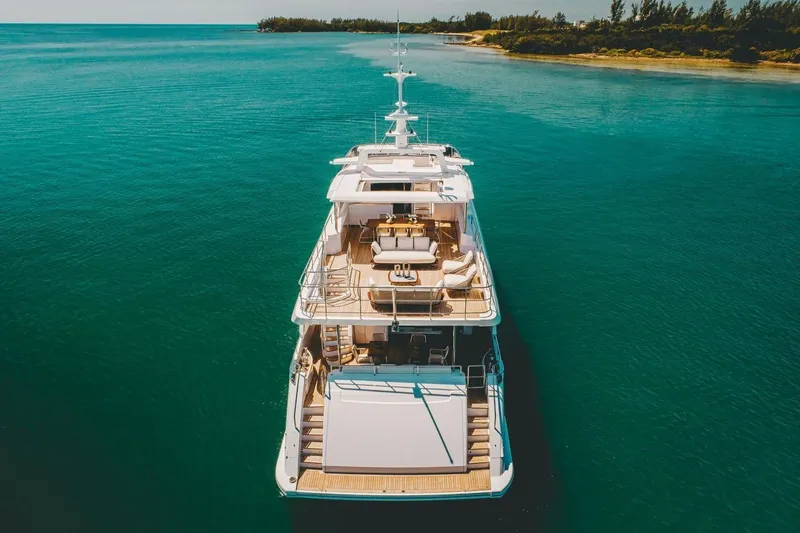 Slide: The Image of Luxurious 2020 Benetti Delfino yacht on serene turquoise waters near a lush coastline. - 5