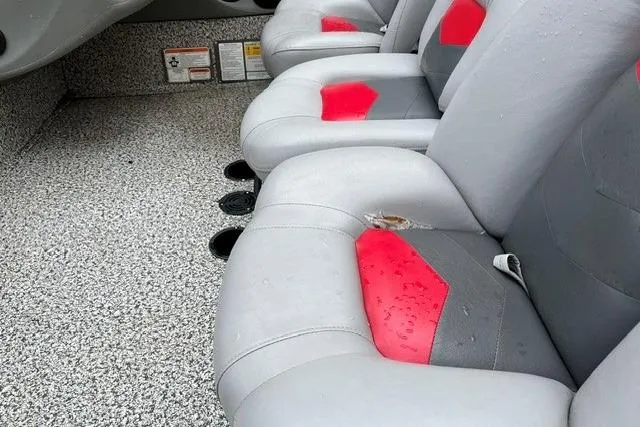 Slide: The Image of 2016 Tracker Pro Team 190 TX boat interior with gray and red seats, wet from rain. - 13
