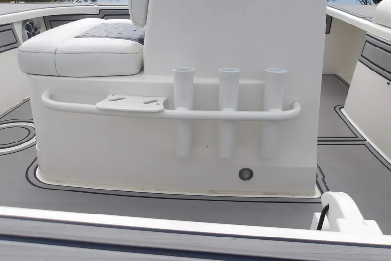 Slide: The Image of 2025 Mako 18 Pro Skiff Patriot Edition boat interior with rod holders and seating. - 10