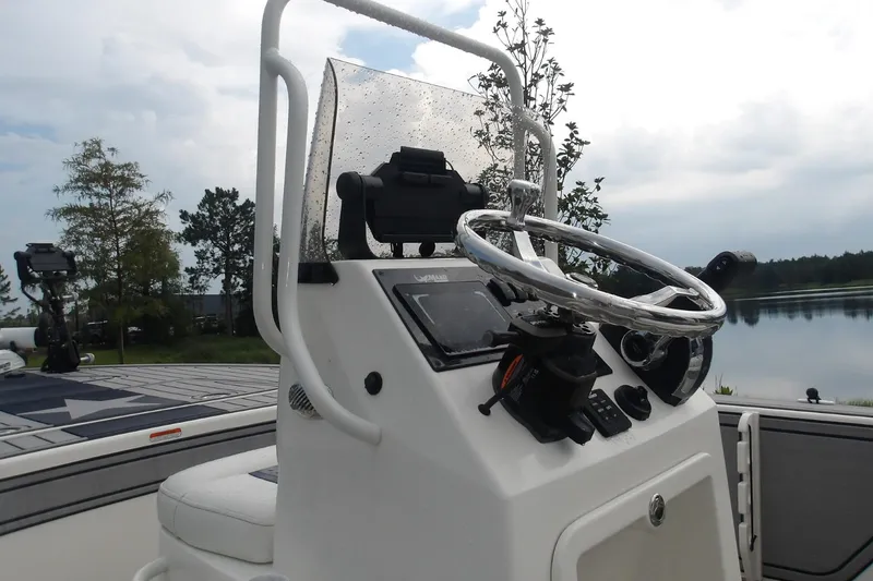 Slide: The Image of 2025 Mako 18 Pro Skiff Patriot Edition boat console with steering wheel and controls. - 13