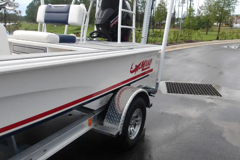 Slide: The Image of 2025 Mako 18 Pro Skiff Patriot Edition on trailer, featuring sleek design and powerful engine. - 4