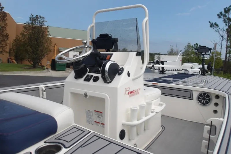 Slide: The Image of 2025 Mako 18 Pro Skiff Patriot Edition boat interior with steering console and seating. - 5
