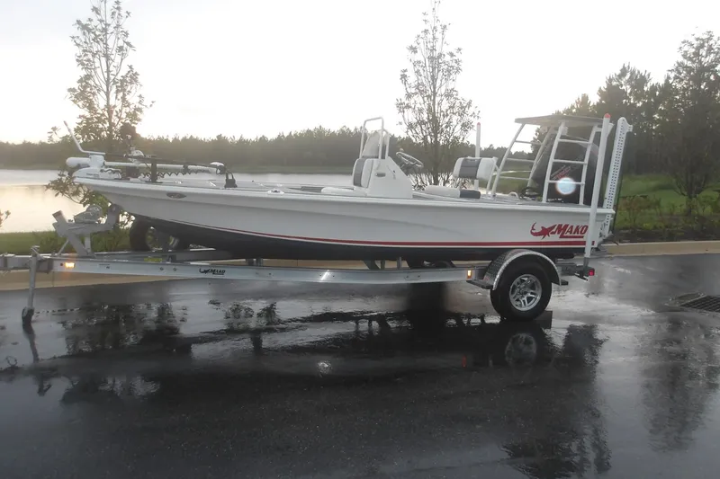 The Image of 2025 Mako 18 Pro Skiff Patriot Edition on trailer by a lake. - 0