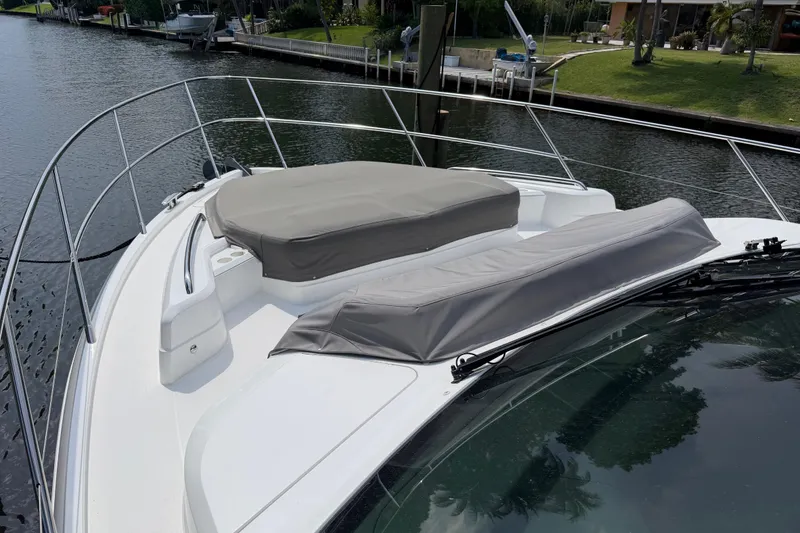 Slide: The Image of 2018 Princess F55 yacht bow with cushioned seating, docked by a serene waterfront. - 26