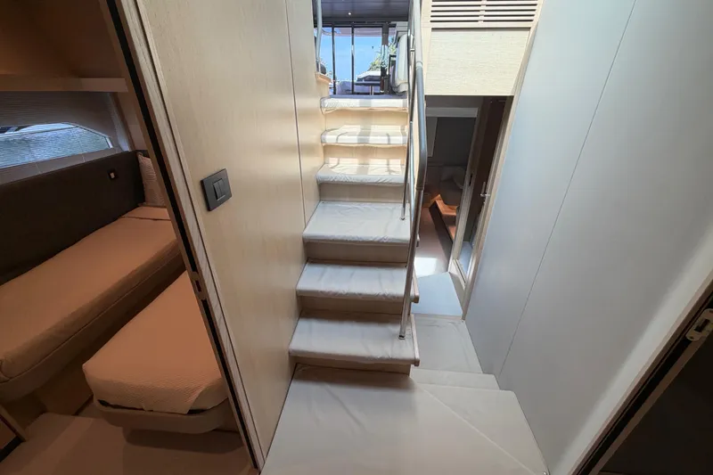 Slide: The Image of Interior of 2018 Princess F55 yacht, featuring a modern staircase and cozy cabin area. - 28