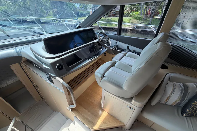 Slide: The Image of Interior of a 2018 Princess F55 yacht cockpit with modern controls and plush seating. - 11
