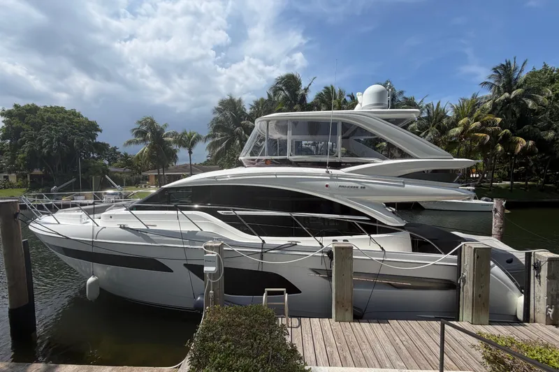 The Image of Luxury 2018 Princess F55 yacht docked by palm trees under a cloudy sky. - 0
