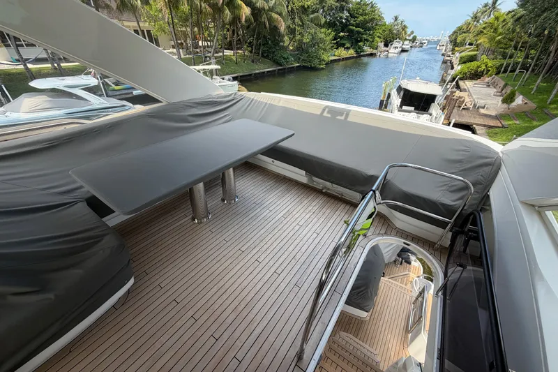 Slide: The Image of Luxurious 2018 Princess F55 yacht deck with seating and table, overlooking a serene waterway. - 23