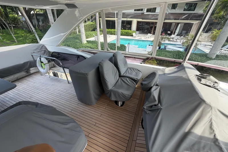 Slide: The Image of Luxurious 2018 Princess F55 yacht deck with covered seating, overlooking a pool and garden. - 25