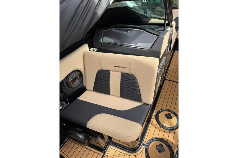 Slide: The Image of 2024 MasterCraft X24 boat interior with beige and black seating. - 11