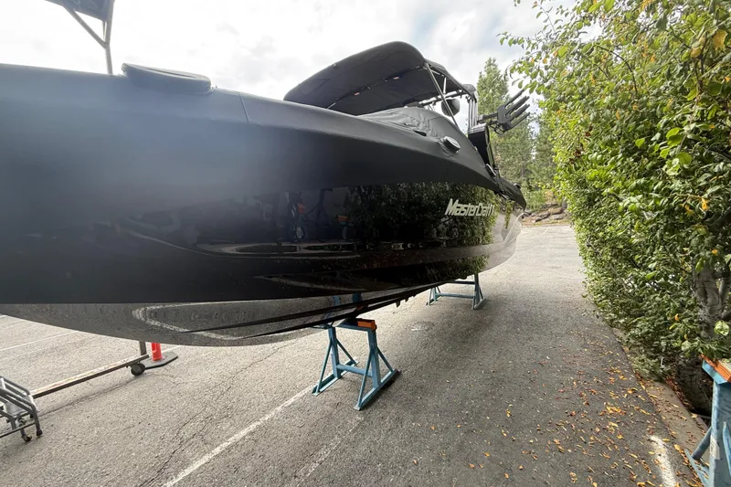 Slide: The Image of 2024 MasterCraft X24 boat on stands, side view, outdoors. - 3