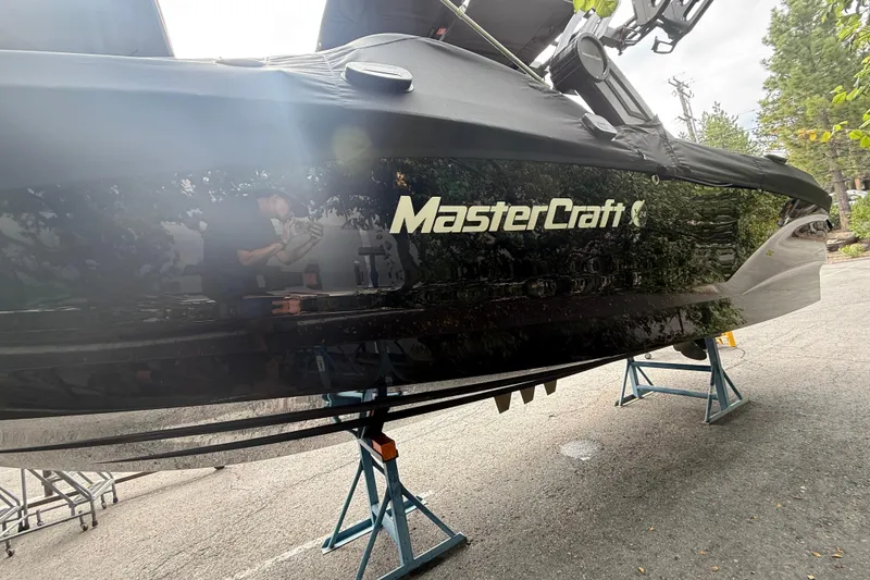 Slide: The Image of 2024 MasterCraft X24 boat on stands, covered and parked outdoors. - 4