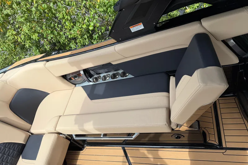 Slide: The Image of The 2024 MasterCraft X24 features luxurious beige and black upholstery with sleek wooden flooring. - 13