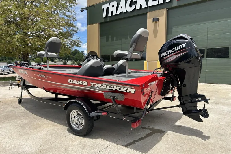 Slide: The Image of 2015 Tracker Pro Team 175 TXW bass boat with Mercury engine, parked outdoors. - 7