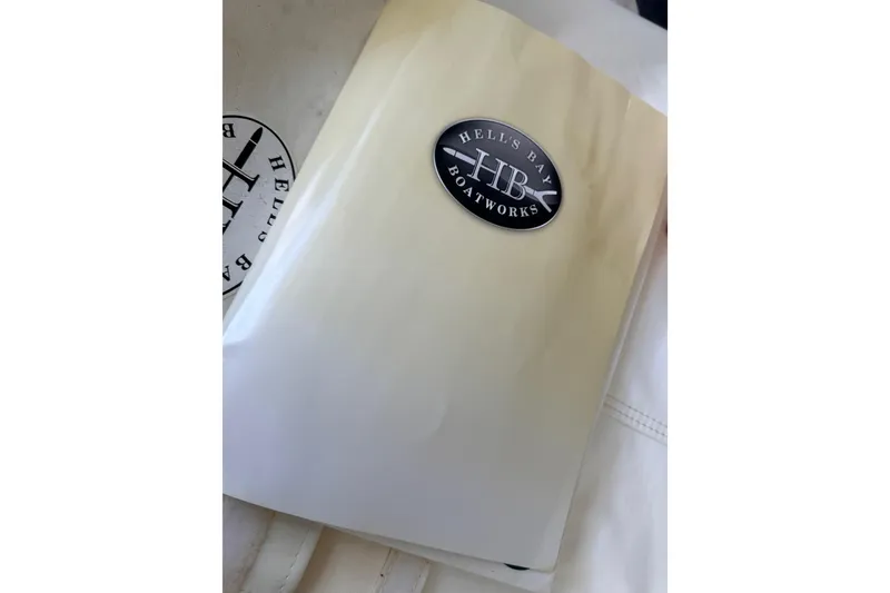 Slide: The Image of Hell's Bay Boatworks logo on 2013 Biscayne model manual cover. - 35
