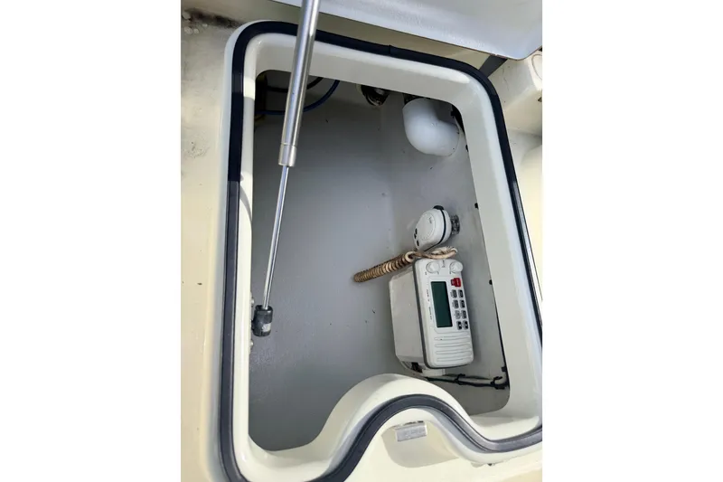 Slide: The Image of 2013 Hell's Bay Biscayne boat compartment with marine radio and coiled rope. - 31