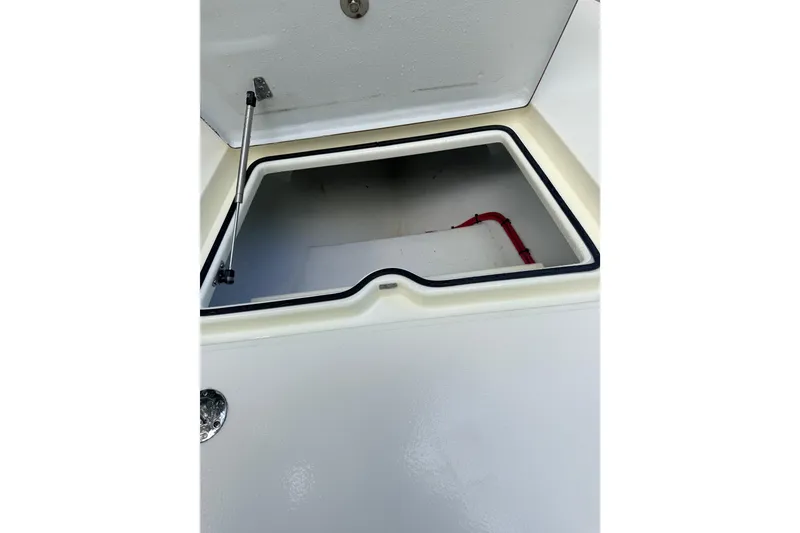 Slide: The Image of Open storage compartment on a 2013 Hell's Bay Biscayne boat, featuring a hydraulic lift. - 28
