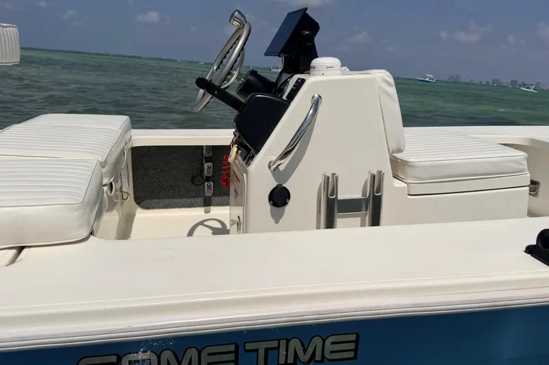 Slide: The Image of 2013 Hell's Bay Biscayne boat interior with white seating and steering console on the water. - 12