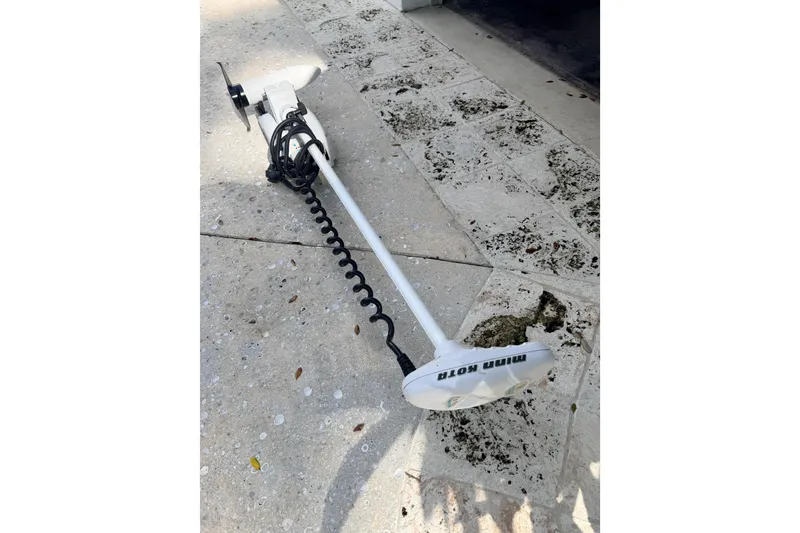 Slide: The Image of Minn Kota trolling motor on concrete, near 2013 Hell's Bay Biscayne boat. - 32