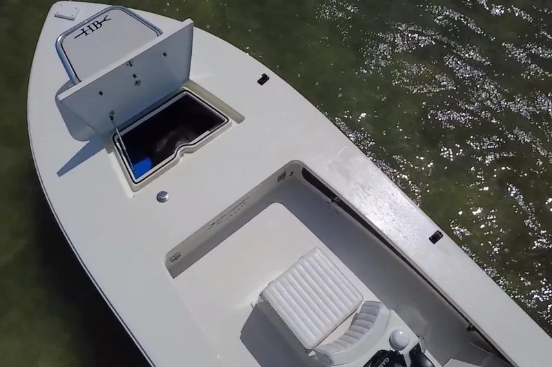 Slide: The Image of 2013 Hell's Bay Biscayne boat on water, open storage compartment, white seating. - 10