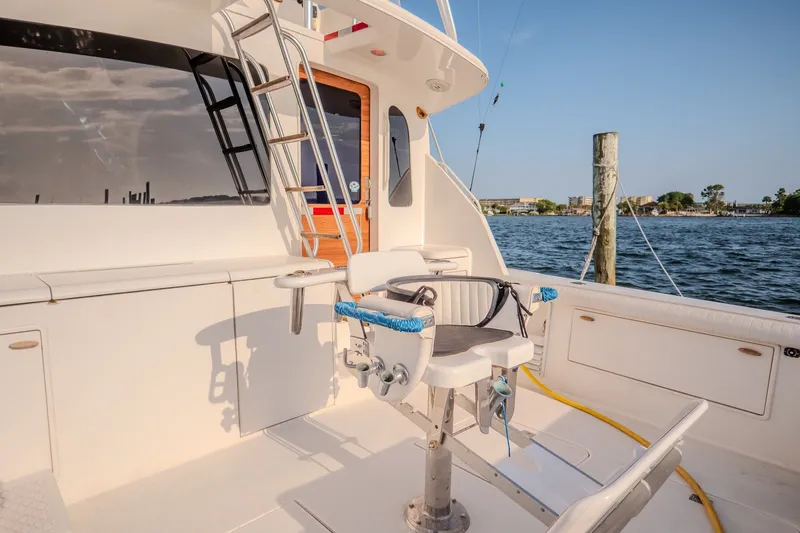 Slide: The Image of Ocean Yachts 48 Super Sport 2000 model, featuring a fishing chair on deck by the water. - 17