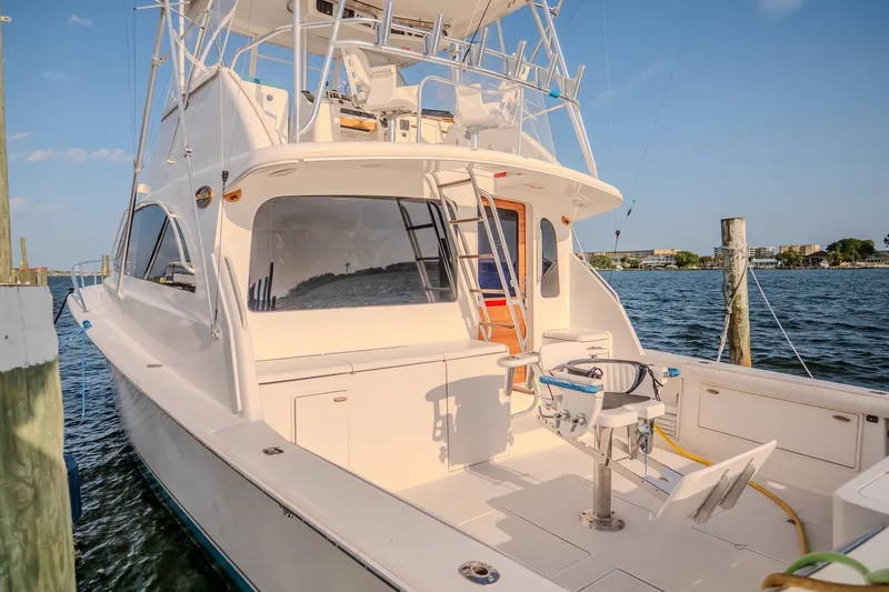 Slide: The Image of Ocean Yachts 48 Super Sport 2000 docked, showcasing spacious deck and fishing chair. - 13