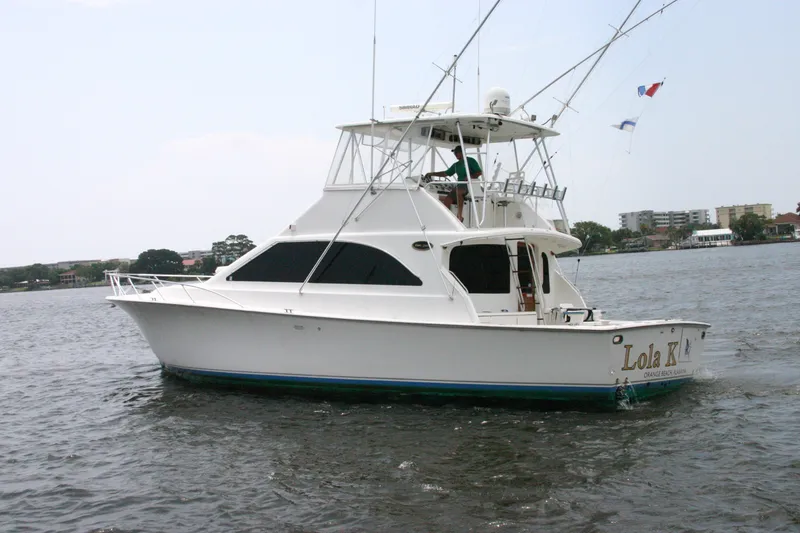 Slide: The Image of Ocean Yachts 48 Super Sport 2000 cruising on water, featuring sleek design and fishing equipment. - 3