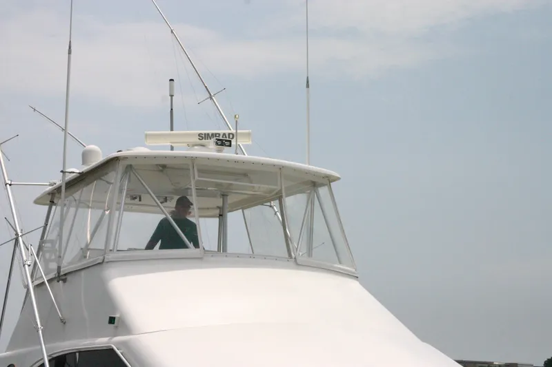 Slide: The Image of 2000 Ocean Yachts 48 Super Sport boat with person in cockpit, clear sky background. - 9