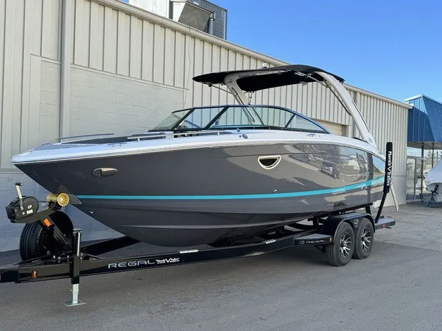 Slide: The Image of 2024 Regal LS6 boat with a gray hull and blue accents on a trailer. - 11