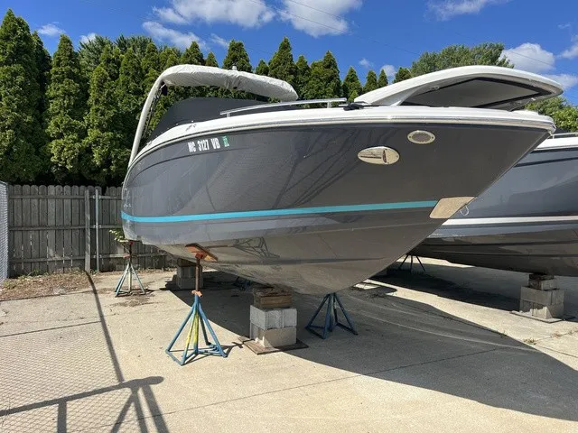 Slide: The Image of A 2024 Regal LS6 boat is on stands in a yard, surrounded by trees. - 23