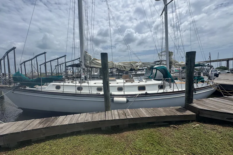 The Image of 1985 Shannon Ketch sailboat docked at marina under cloudy sky. - 1
