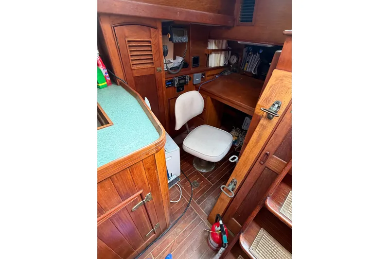 Slide: The Image of 1985 Shannon Ketch interior with wooden cabinetry and navigation station. - 8