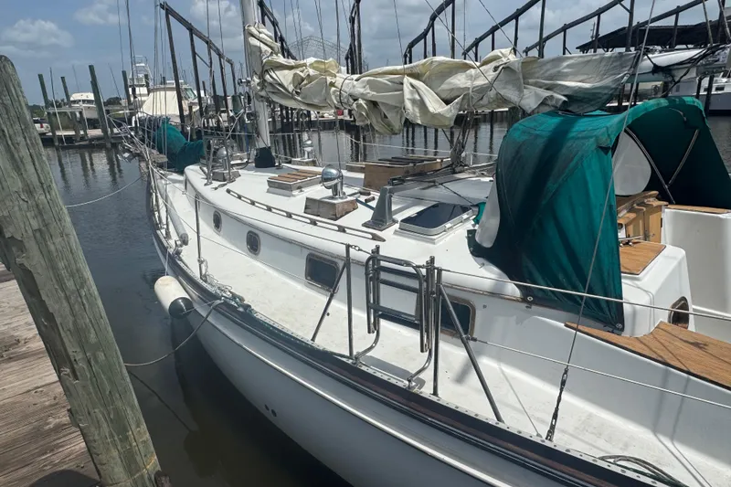 Slide: The Image of 1985 Shannon Ketch sailboat docked at marina, featuring green covers and wooden deck. - 4