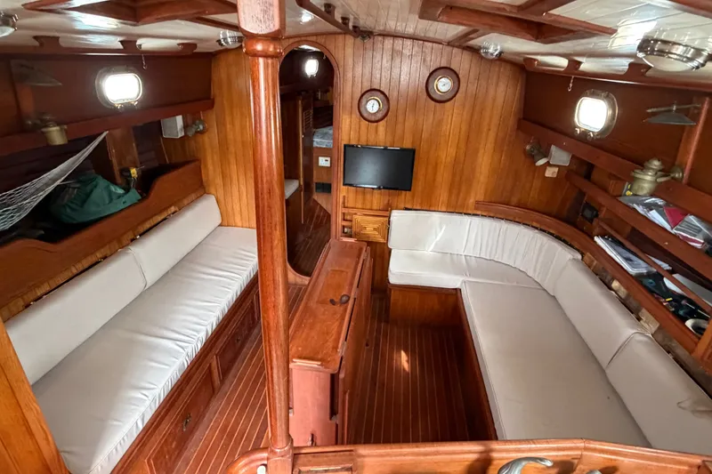 Slide: The Image of Interior of a 1985 Shannon Ketch sailboat with wooden paneling and cozy seating. - 5