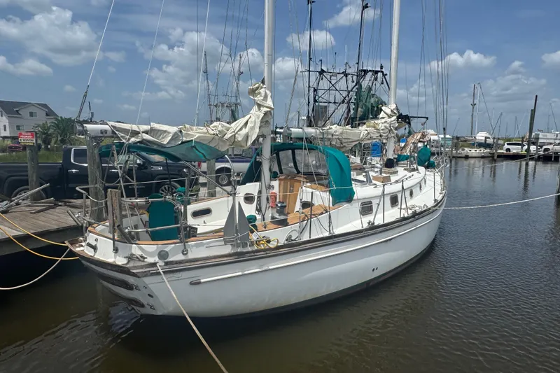 Slide: The Image of 1985 Shannon Ketch sailboat docked at marina under blue sky. - 3