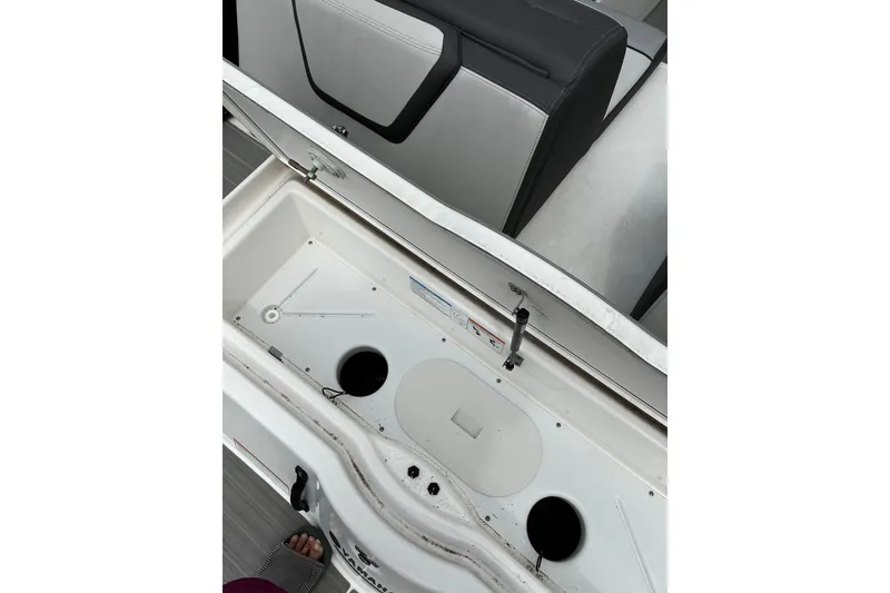 Slide: The Image of 2023 Yamaha Boats AR250 storage compartment with open lid and seating detail. - 26