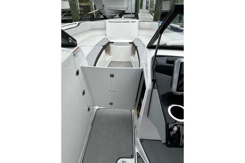 Slide: The Image of 2023 Yamaha Boats AR250 interior with open storage compartment and seating area. - 14