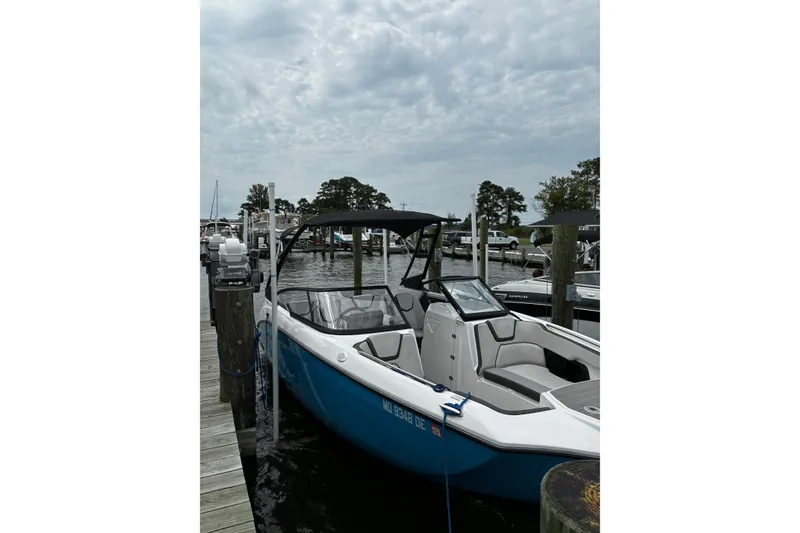 Slide: The Image of 2023 Yamaha Boats AR250 docked at a marina under a cloudy sky. - 30